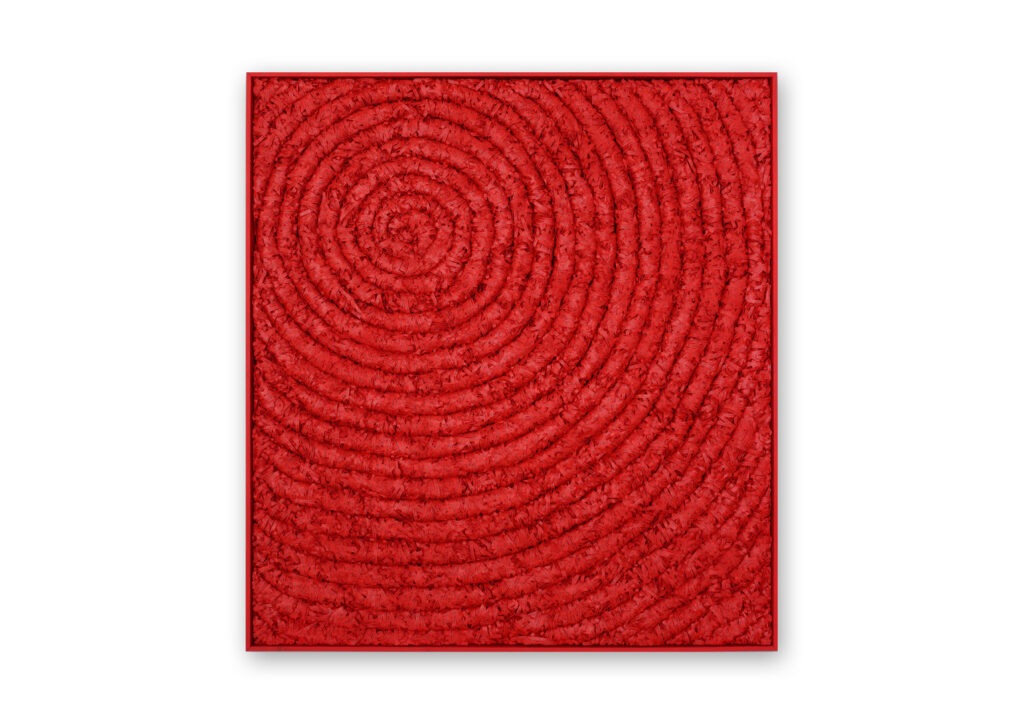Senza titolo 2018, opera d'arte contemporanea a tecnica mista di cm 117 x 127, collezione privata. Quadro di colore rosso, con una cornice sottile in tinta, interamente formato da strisce di carta scritte e arrotolate di colore rosso affiancati l'uno all'altro che si allargano a spirale partendo da un centro in alto a sinistra. Opera realizzata dall'artista Giovanni Fava.