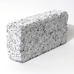 Another word in the brick 2020, scultura e opera d'arte contemporanea a tecnica mista di cm 12 x 25 x 6. L'opera presenta uno sviluppo tridimensionale a forma di singolo mattone rettangolare, formata da un fitto e compatto intreccio materico di strisce di carta bianca modellate con fitte tracce di scrittura. Opera realizzata dall'artista Giovanni Fava.