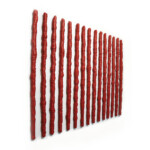 Senza titolo 2023, opera d'arte contemporanea a tecnica mista su carta e legno di cm 150 x 125. La composizione è formata da 15 elementi verticali irregolari affiancati, realizzati con strisce di carta arrotolate di colore rosso con una fitta texture di scrittura. Opera realizzata dall'artista Giovanni Fava.